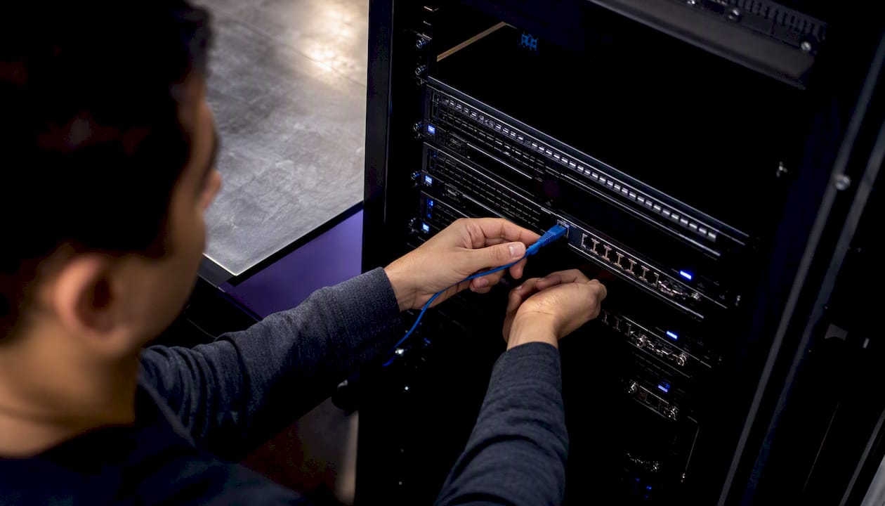 Hands connecting network cable for load testing