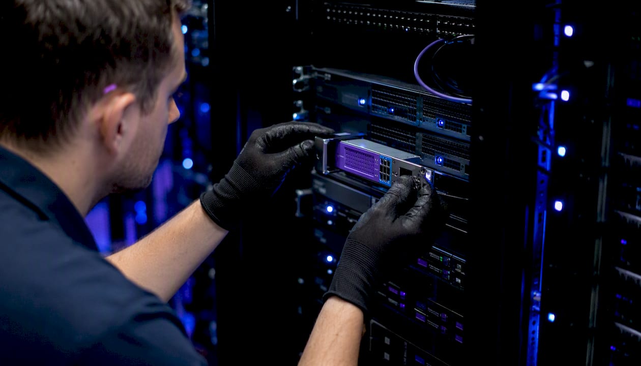 Hands installing security hardware token in server rack