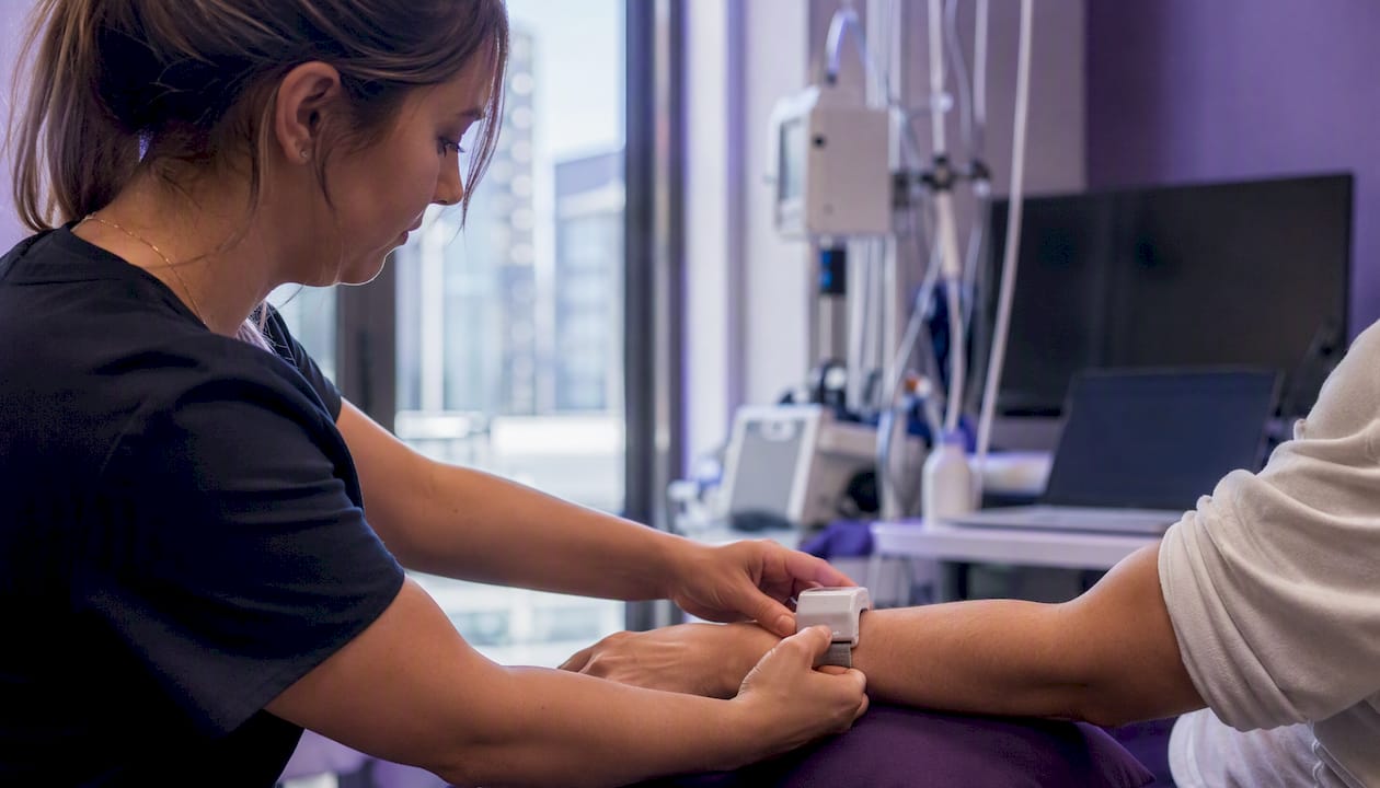 Hands fitting wearable telemetry device on arm