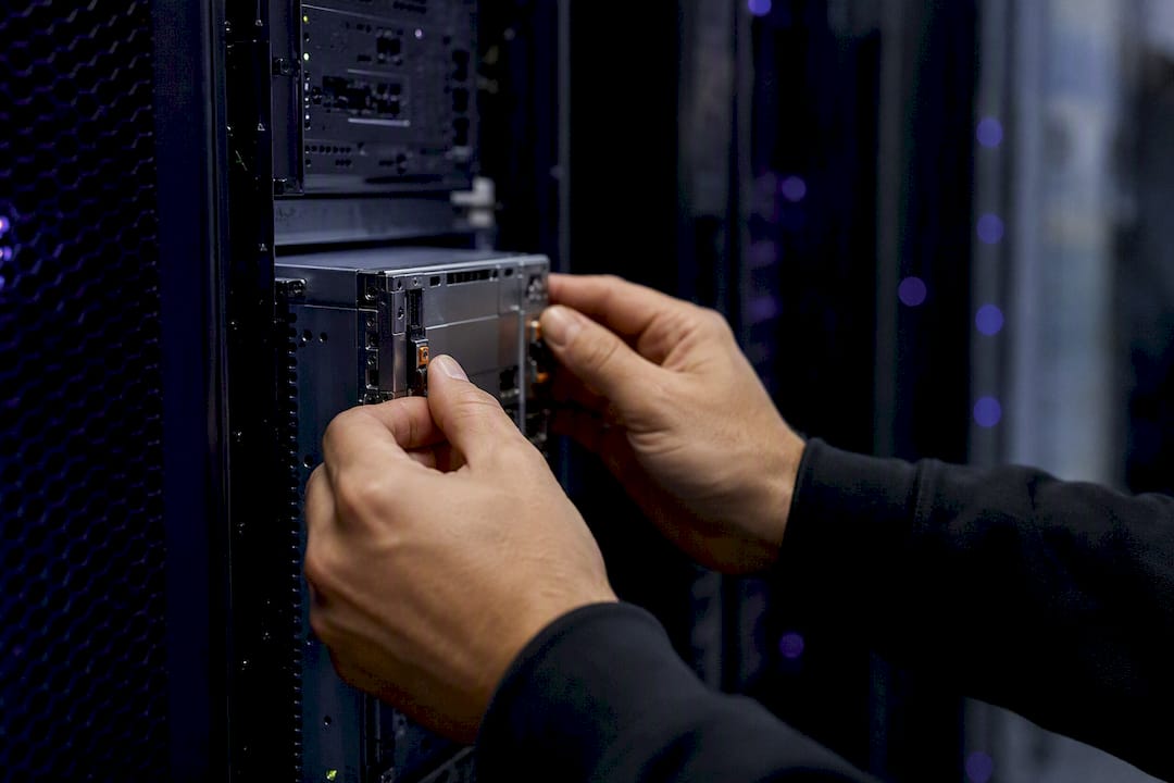 Hands configuring modular device in server room