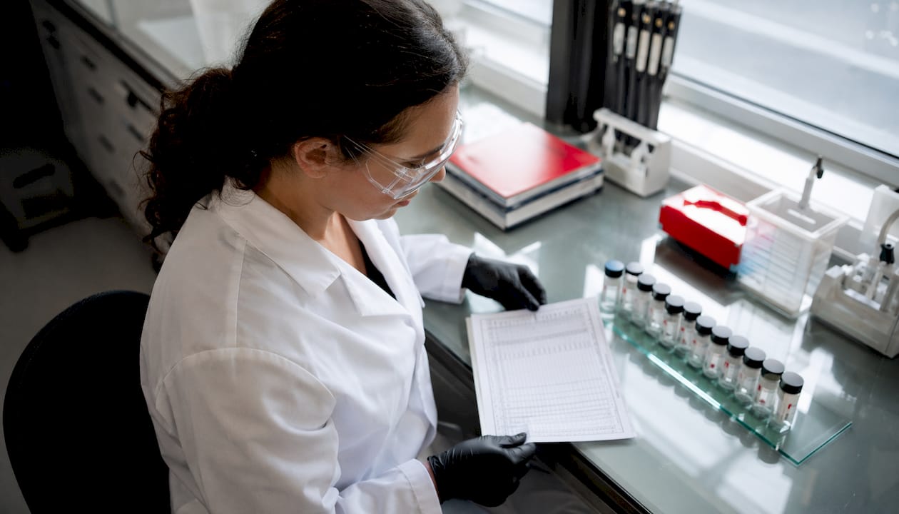 Lab technician reviewing calibration certificate and reference materials