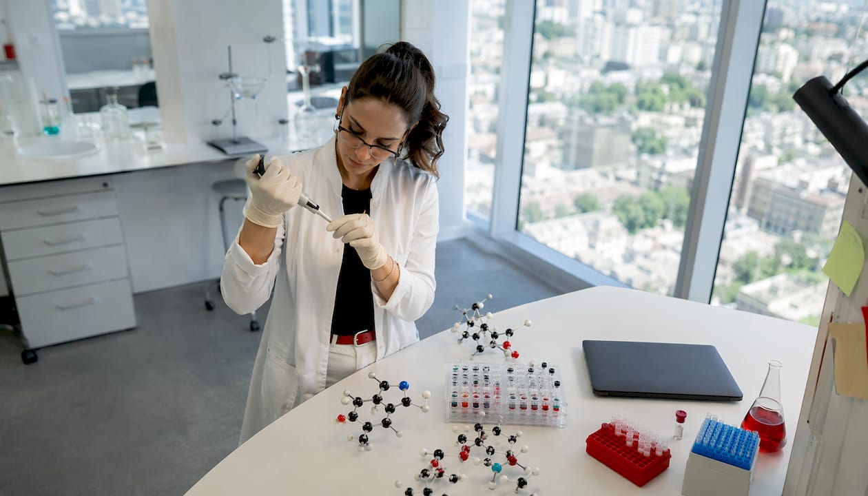 Pharmacologist working at lab bench with molecular models