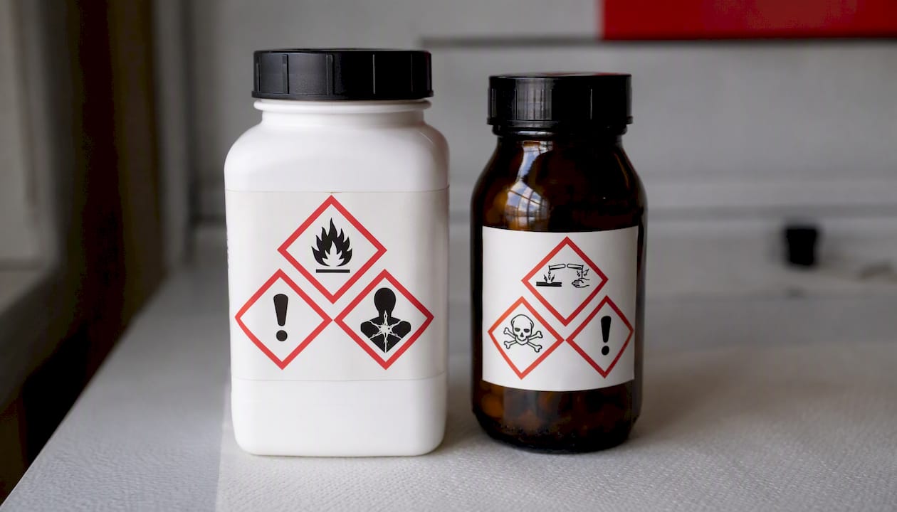 Close-up of hazardous material labels on lab bottles