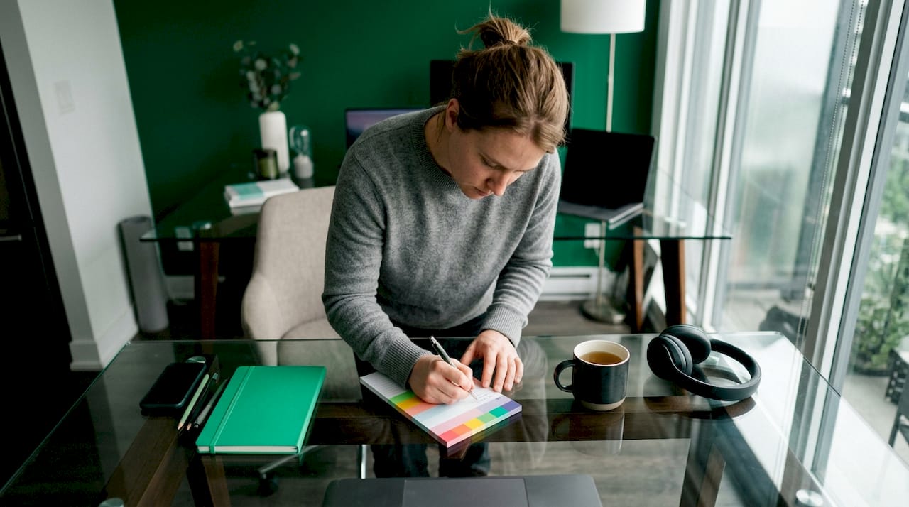 Entrepreneur writing business plan at home table