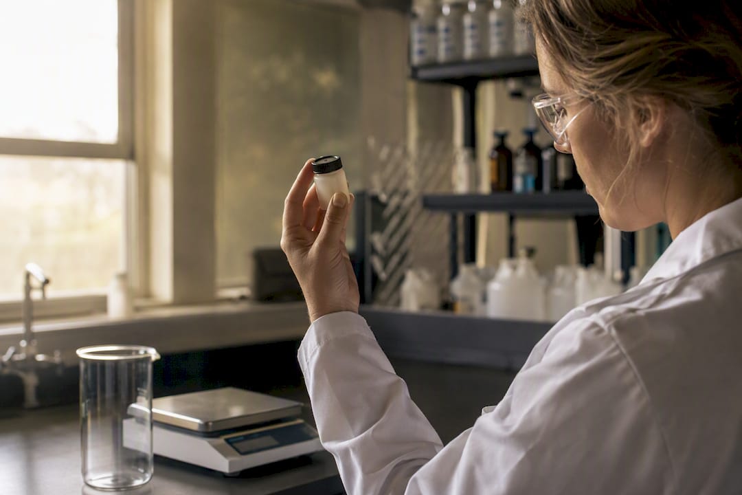 Chemist holding confidential chemical formula vial