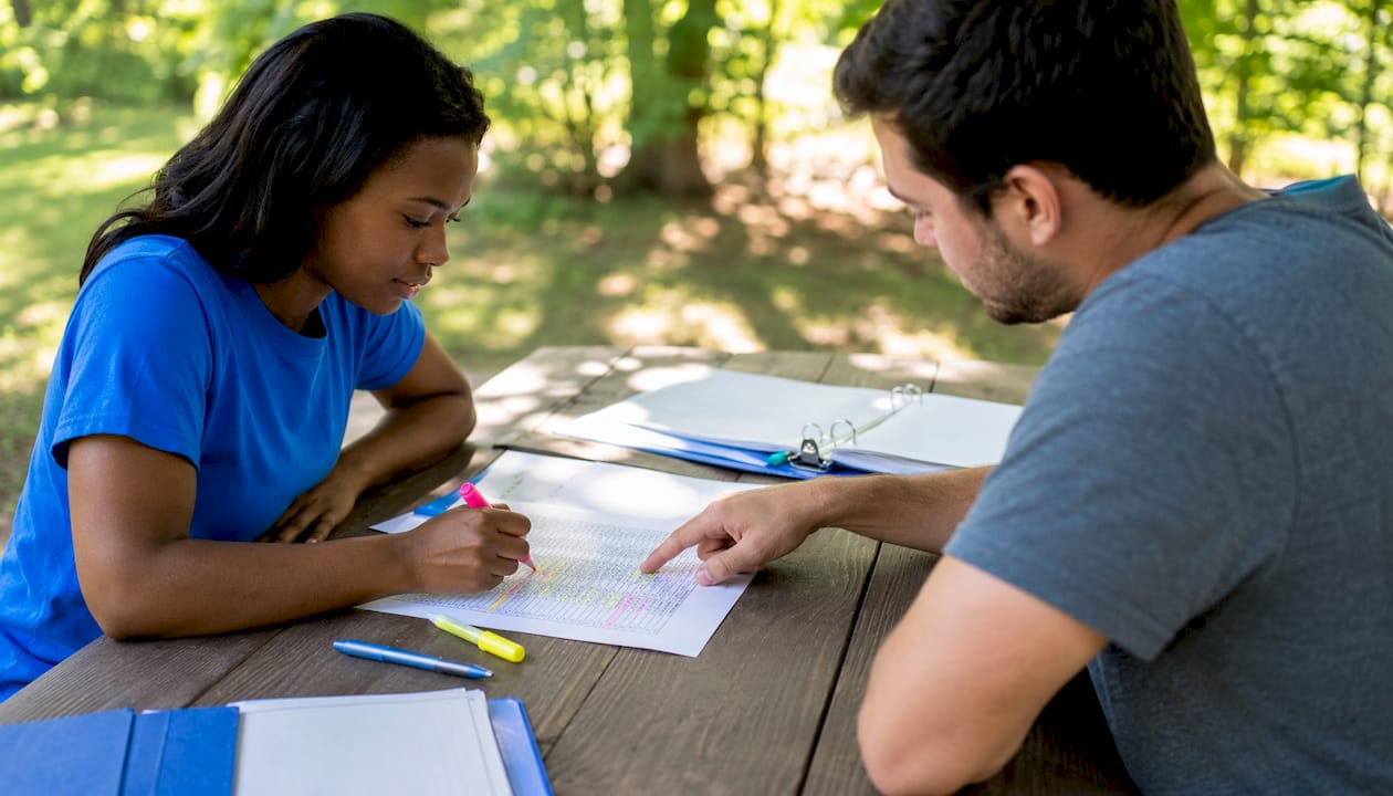 Two people organizing clinical volunteer hour logs