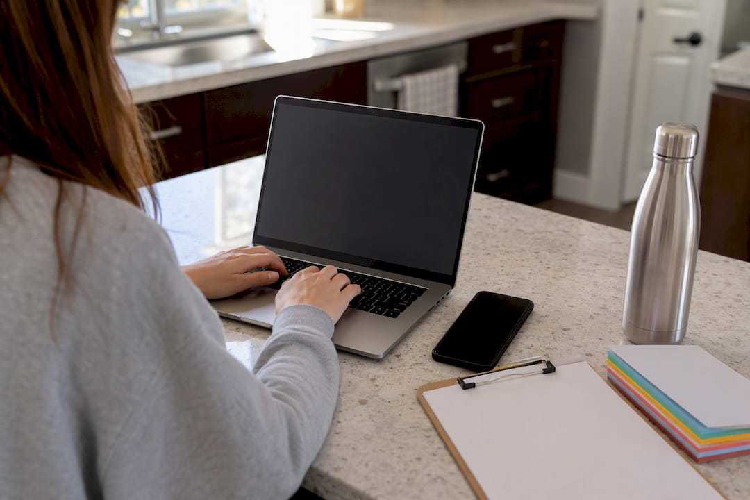 Hands typing transcript request email with calendar visible