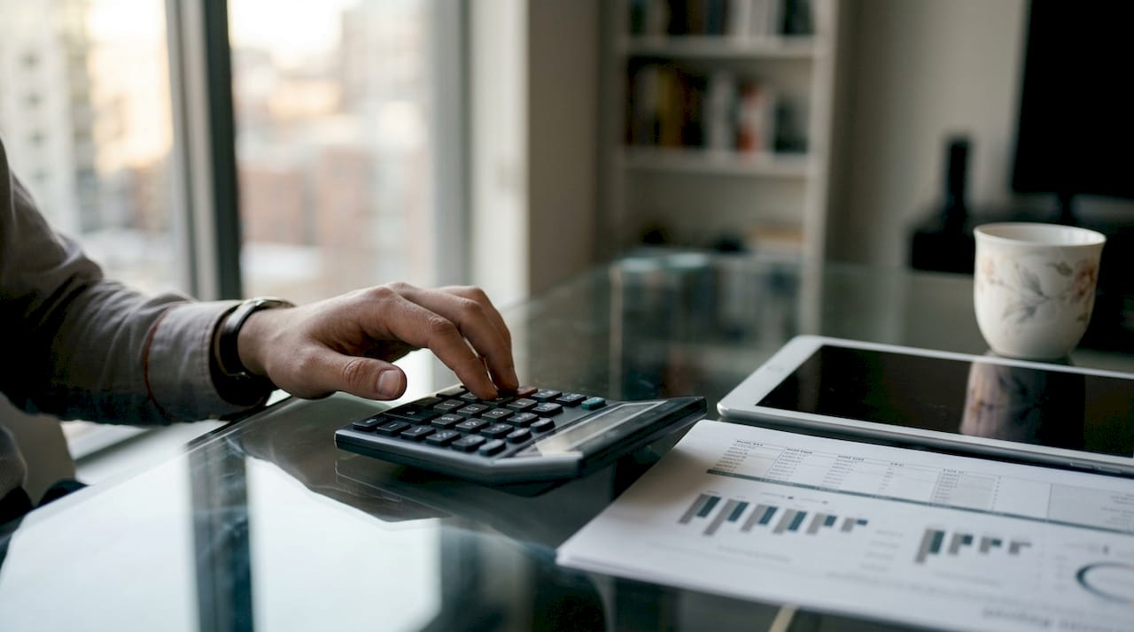 Hands calculating advertising metrics with calculator