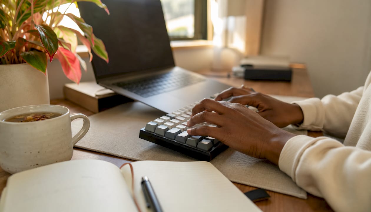Close-up of hands typing code on laptop keyboard
