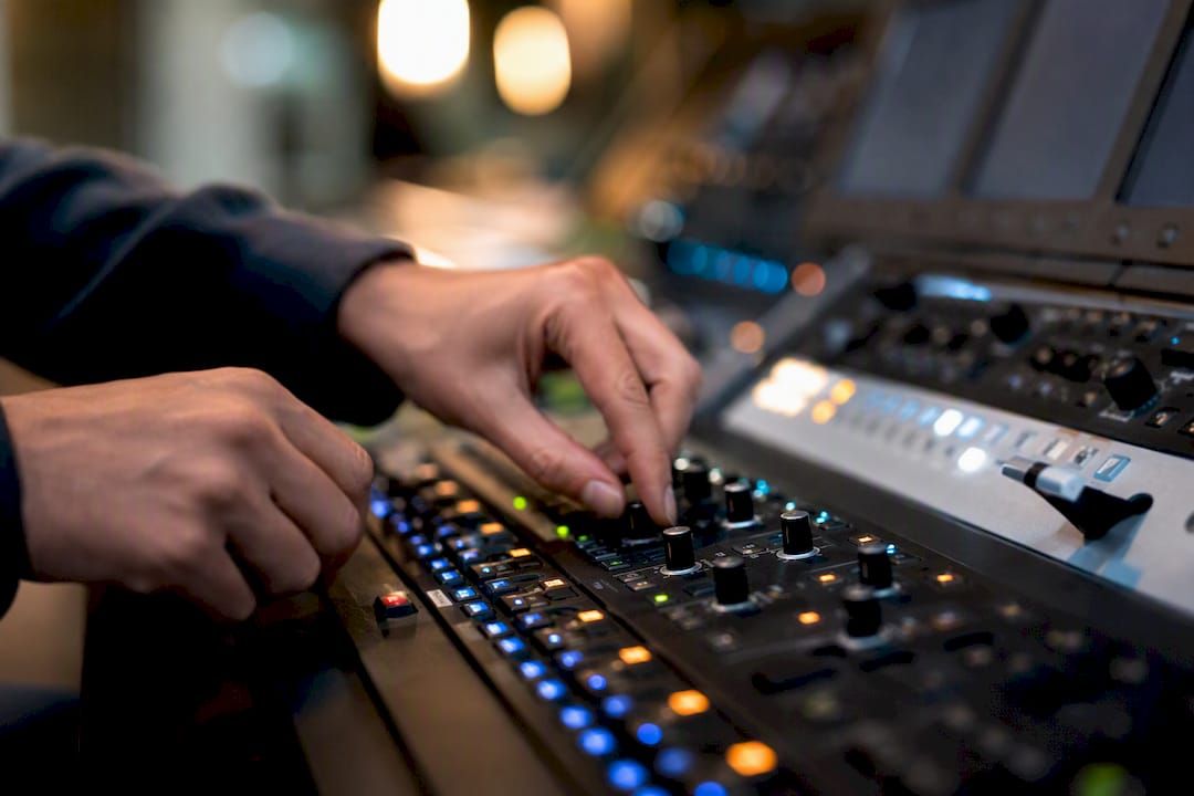 Hands adjusting control panel knobs
