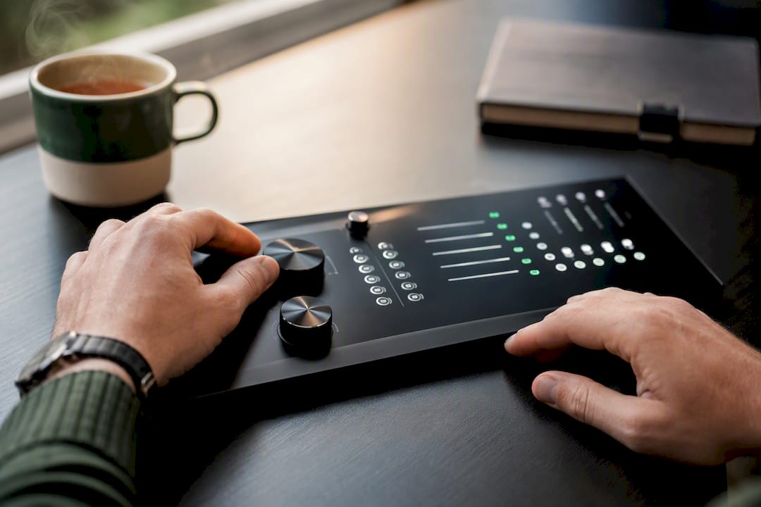 Hands turning control dials on marketing console