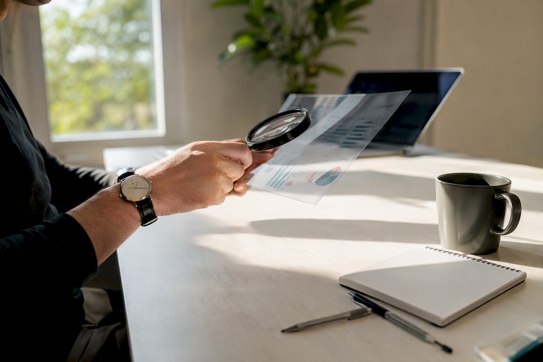 Hands inspecting PPC data with magnifying glass