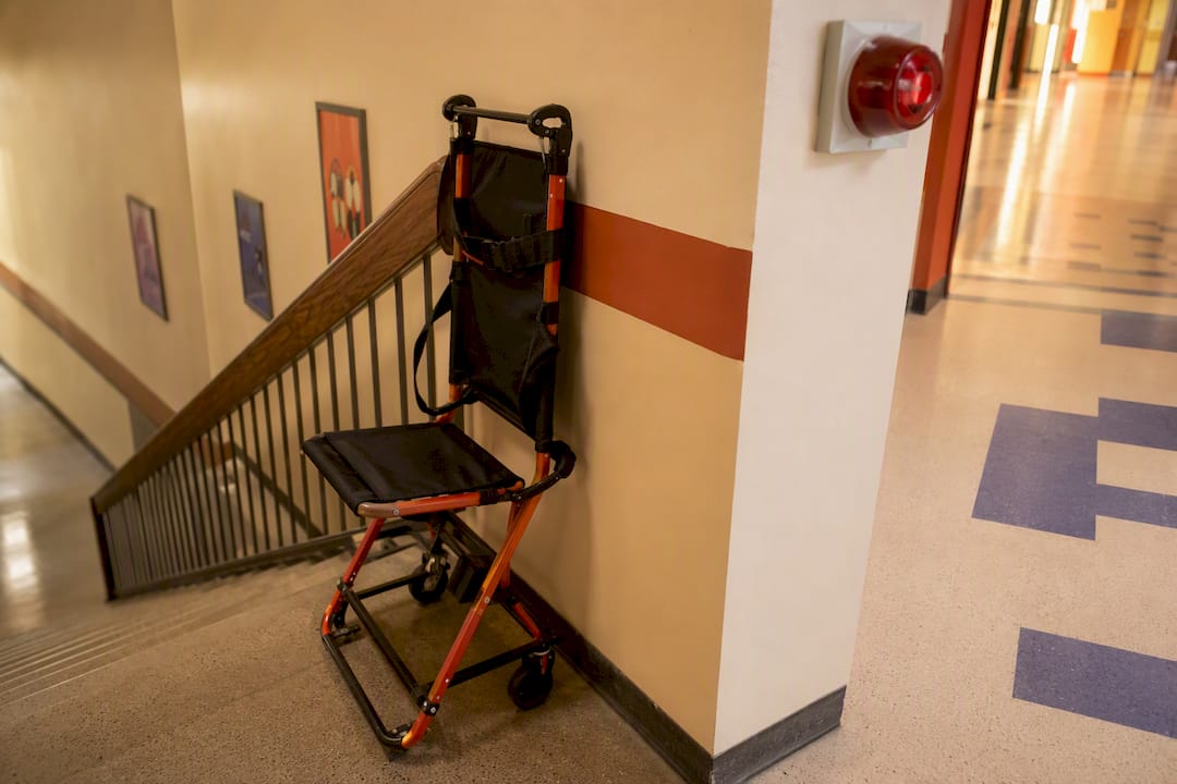 Evacuation chair by stairwell in school corridor