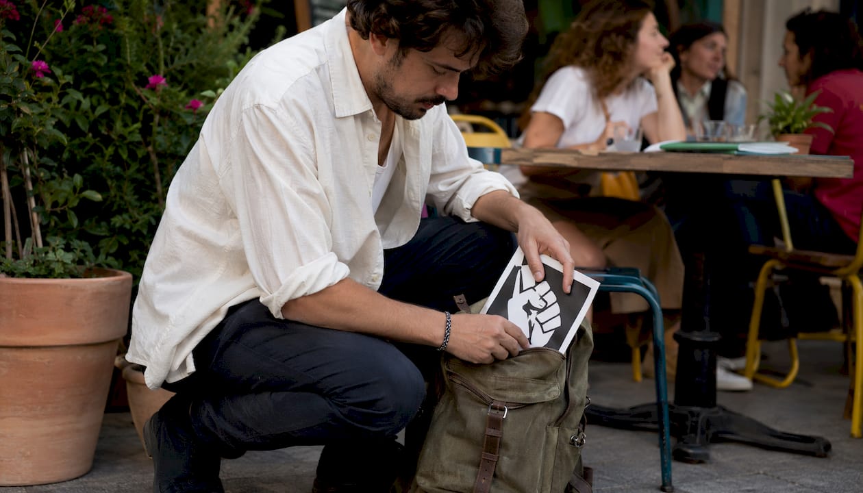 Hands placing flyer into tote bag at market