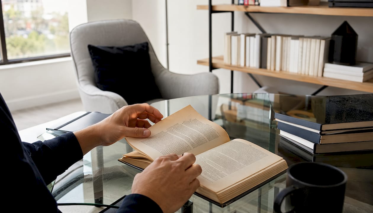 Hands turning historic economic policy book pages