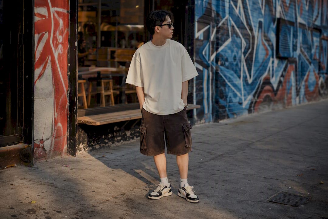 Person wearing boxy tee and cargo shorts in urban alley