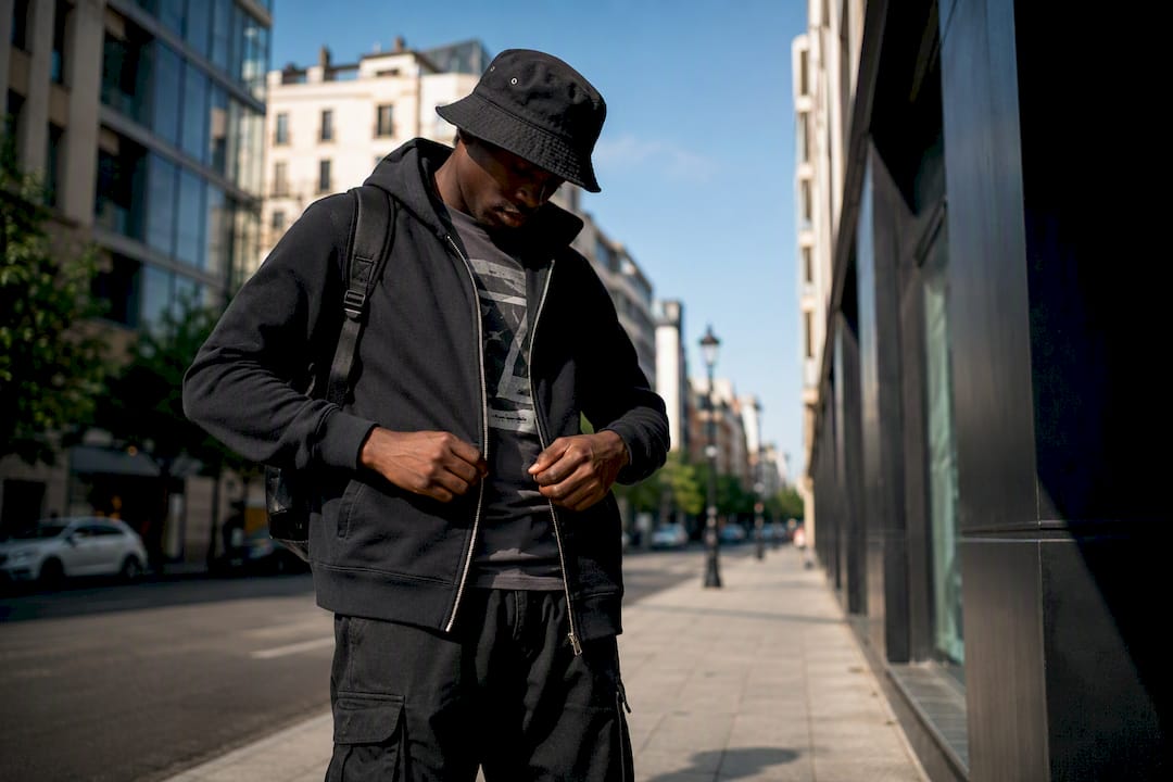Person half-zipping streetwear hoodie outfit