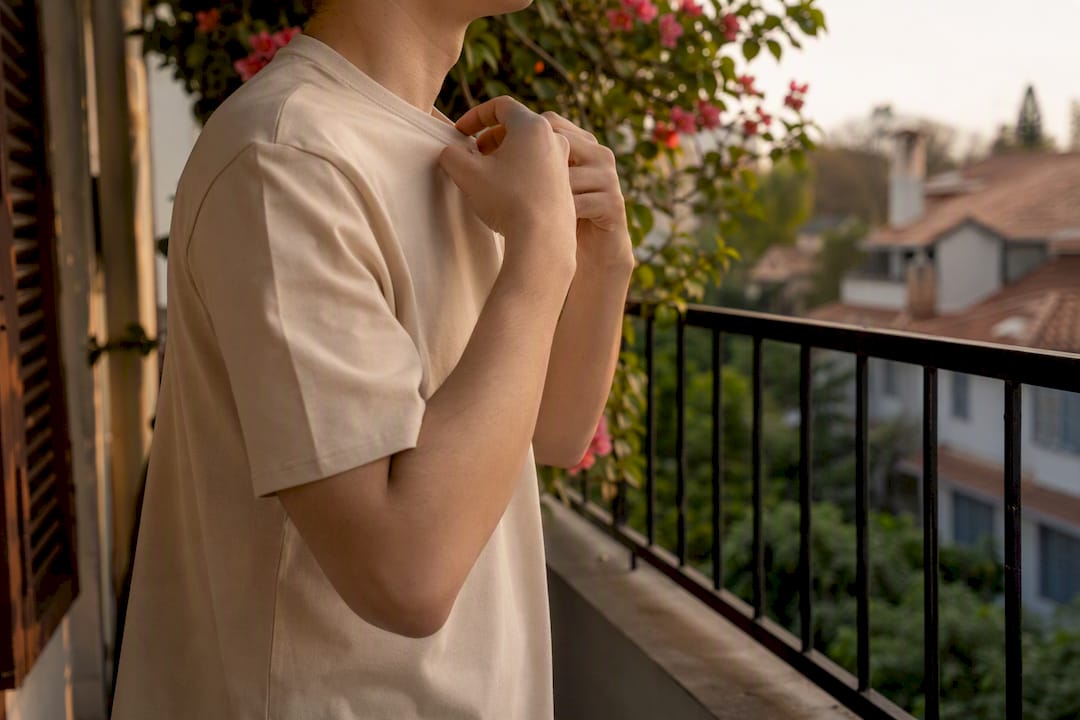 Hands adjusting sleeve and shoulder of unisex T-shirt