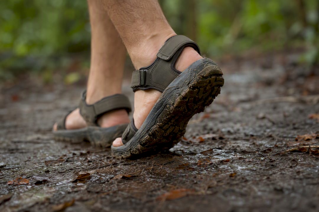 Durable youth group sandals on muddy trail