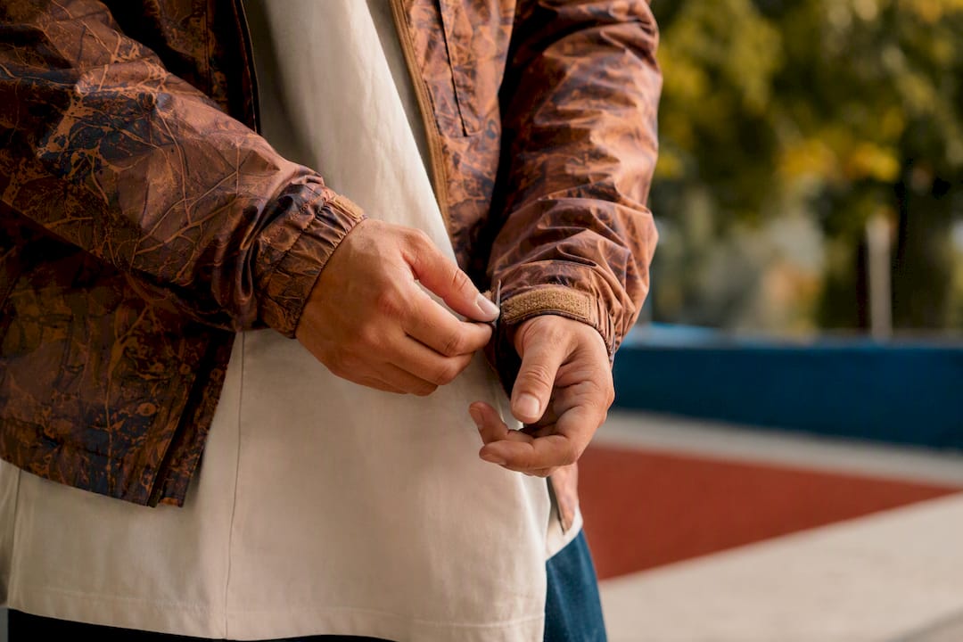 Hands adjusting jacket cuff layering