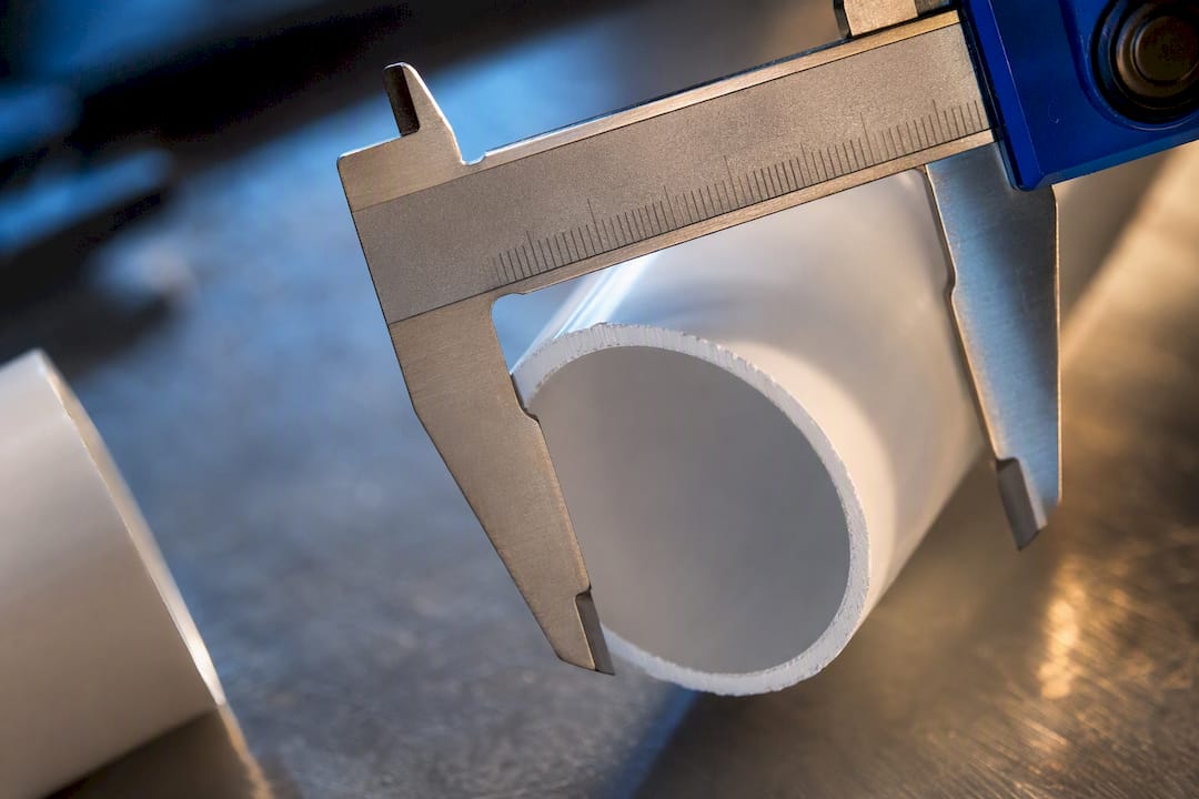 Caliper measuring PVC pipe outside diameter