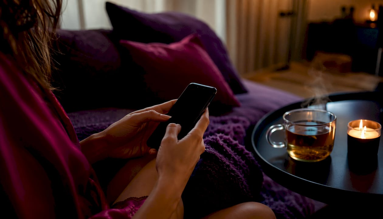 Hands scrolling kink-aware dating app on phone