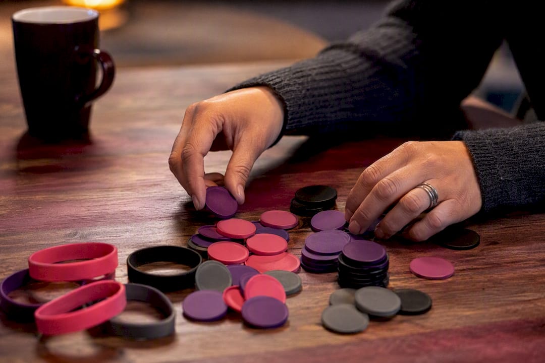 Hands selecting varied consent tokens for negotiation