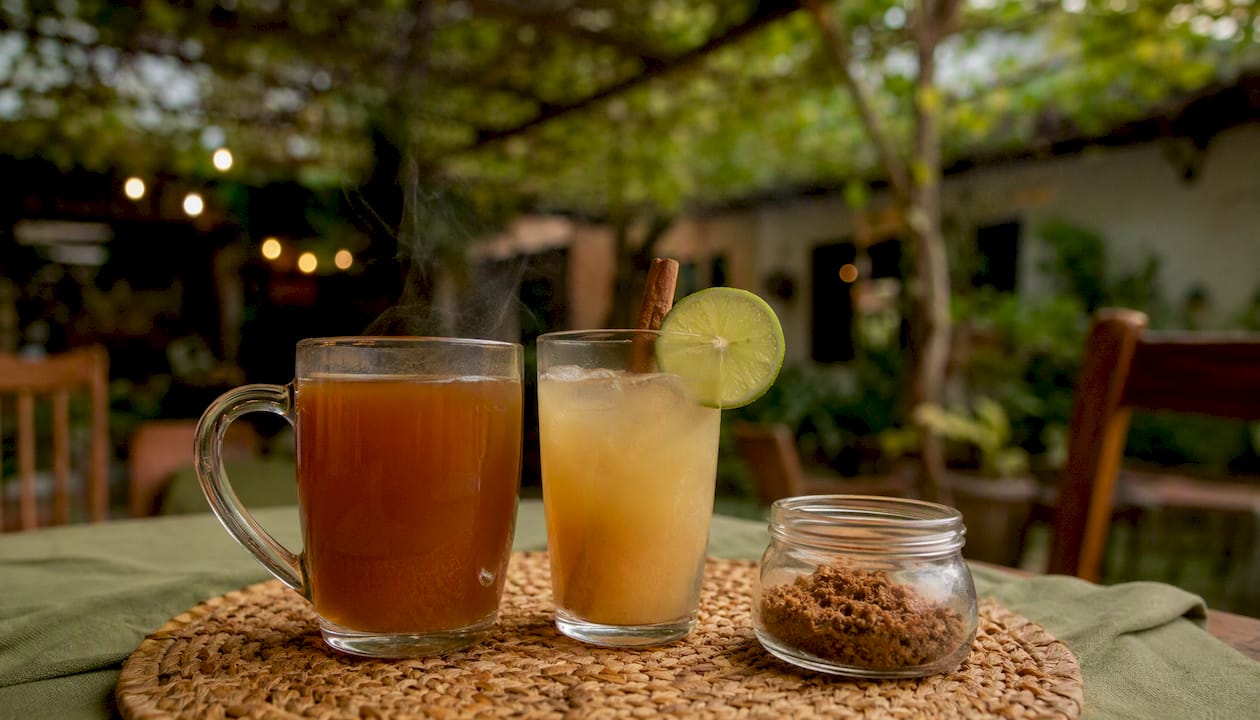 Hot aguapanela in glass mug and cold limonada with lime and cinnamon
