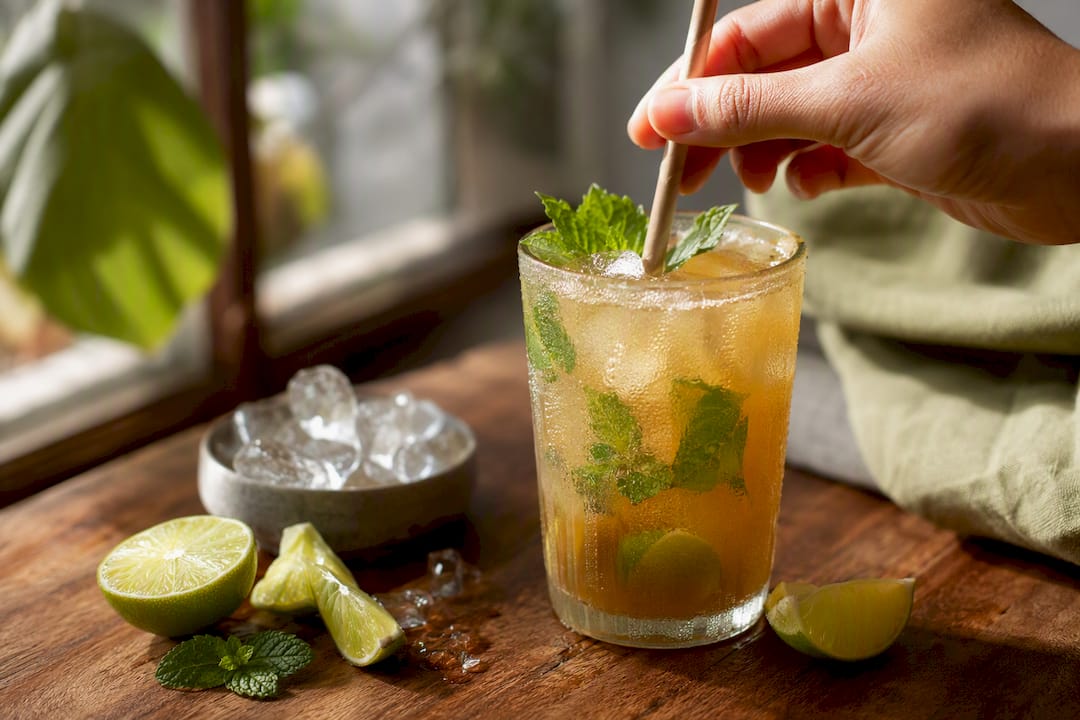 Glass of cold aguapanela limeade with mint