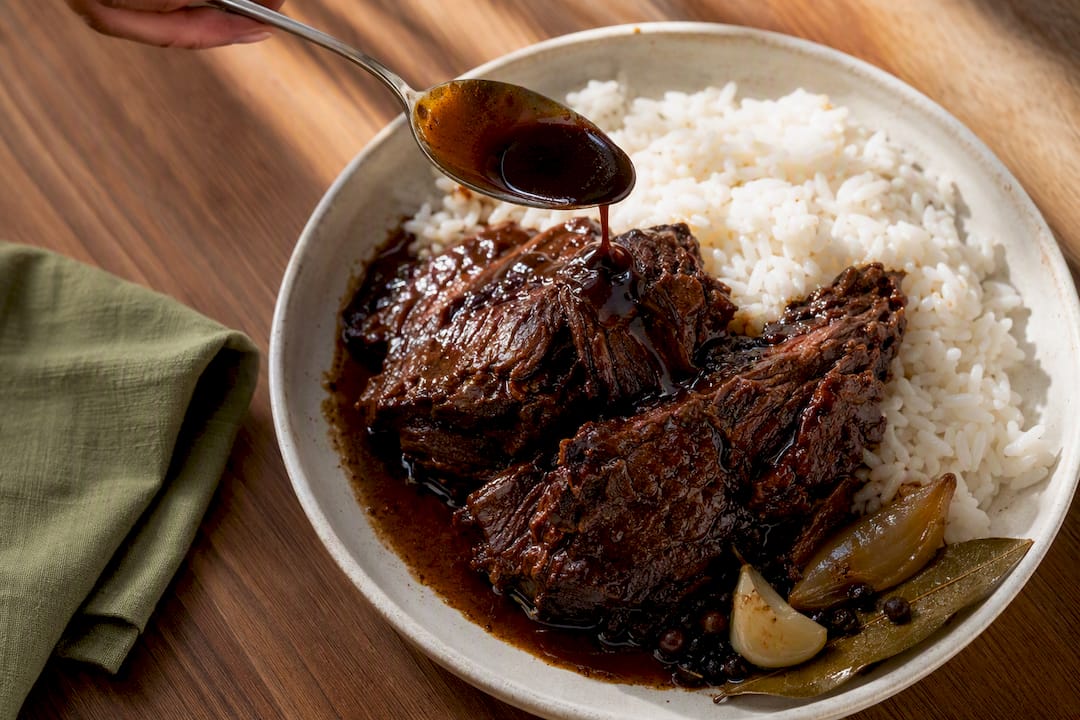 Reduced panela sauce spooned over beef and rice