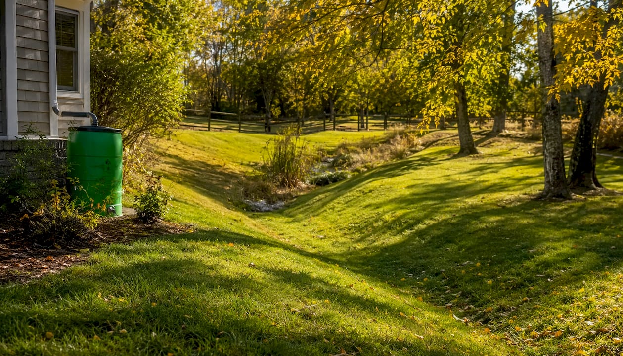 Grass swale and berm directing water in yard