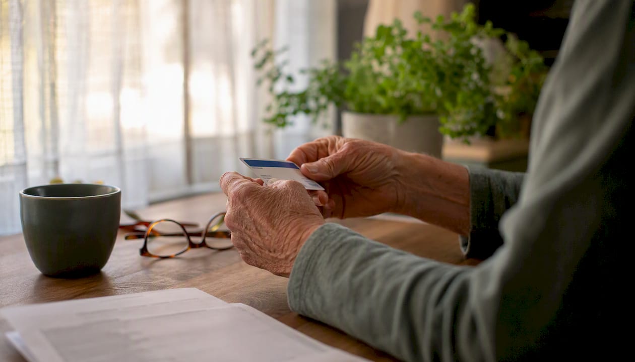 Senior hands holding Medicare card and medical bill