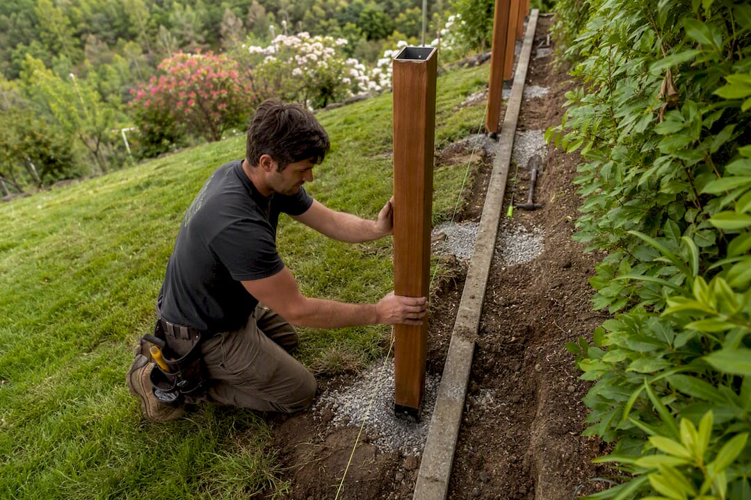 Installer placing steel u-channel post in gravel base
