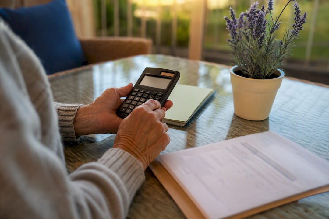 Hands adjusting calculator by annuity contract