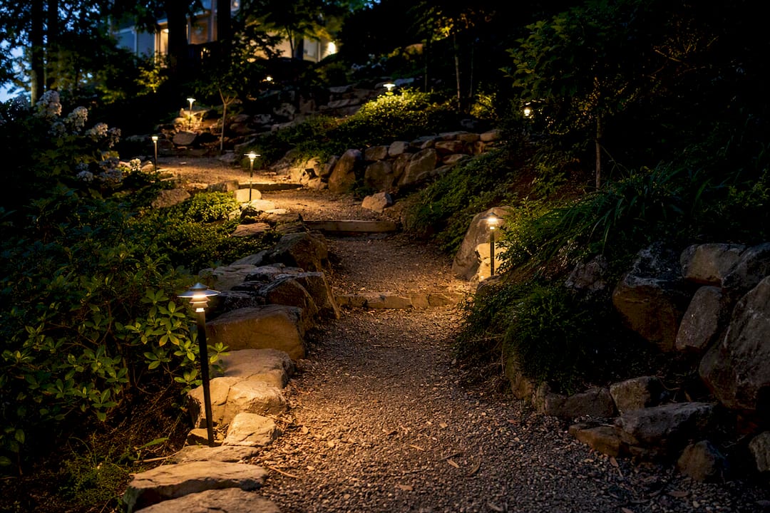 Evening lighting illuminating backyard stairs on slope
