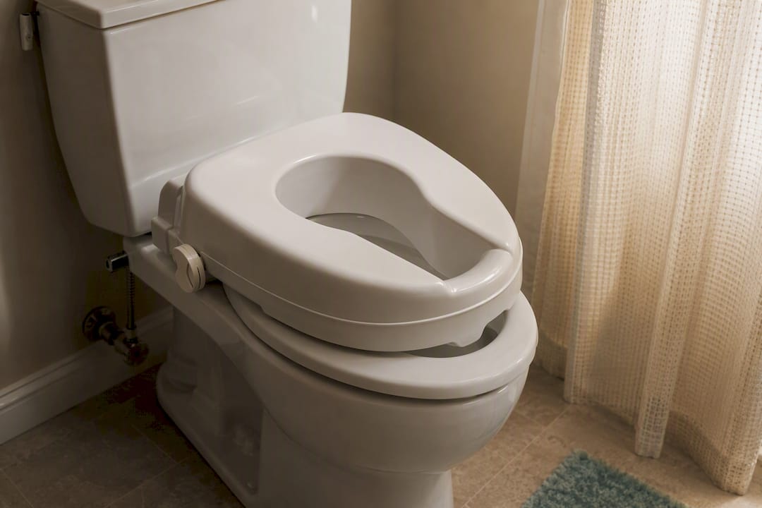 Raised toilet seat in home bathroom