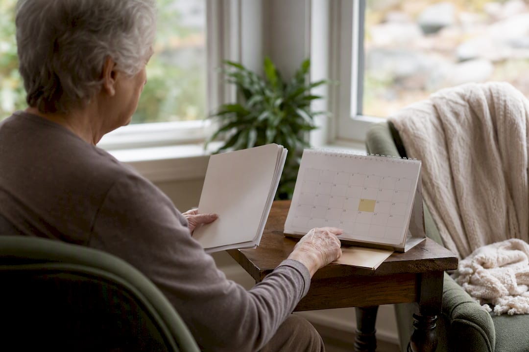 Hands holding Medicare booklet and calendar