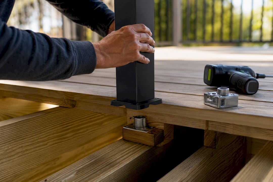 Railing post anchored to deck framing