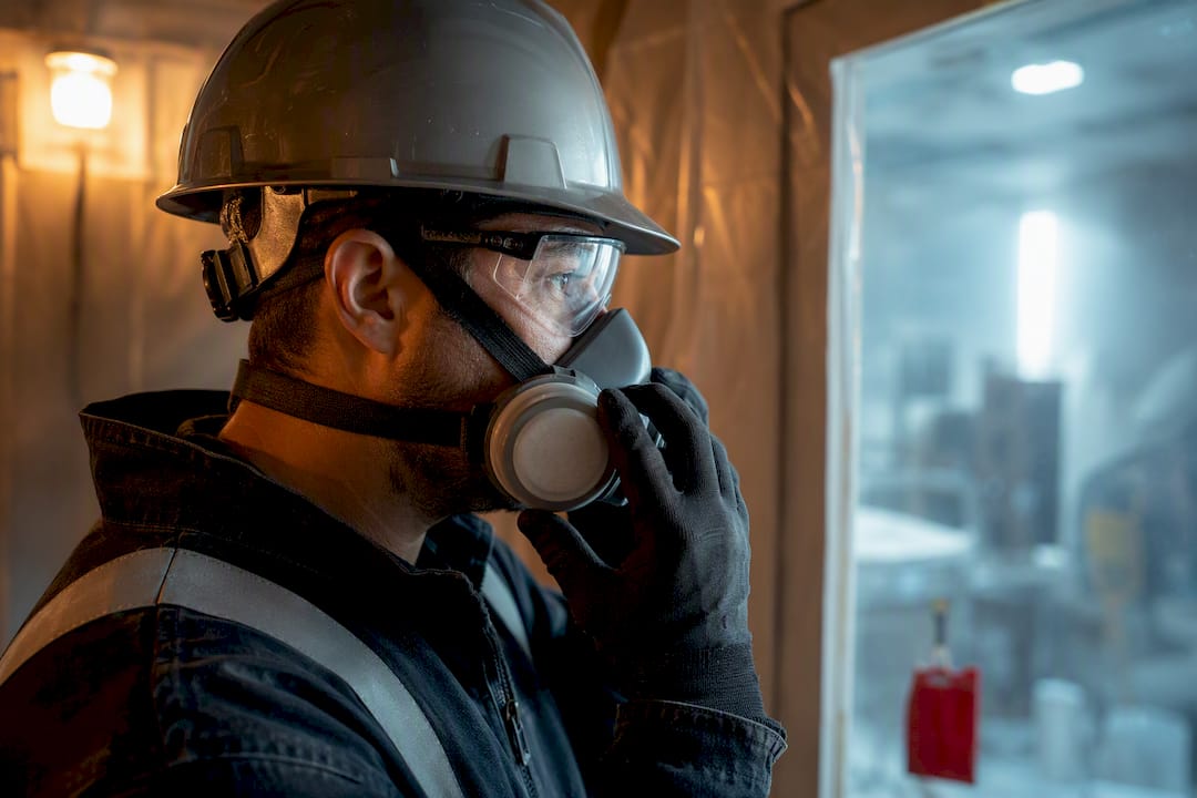 Worker wearing respirator during dusty demolition