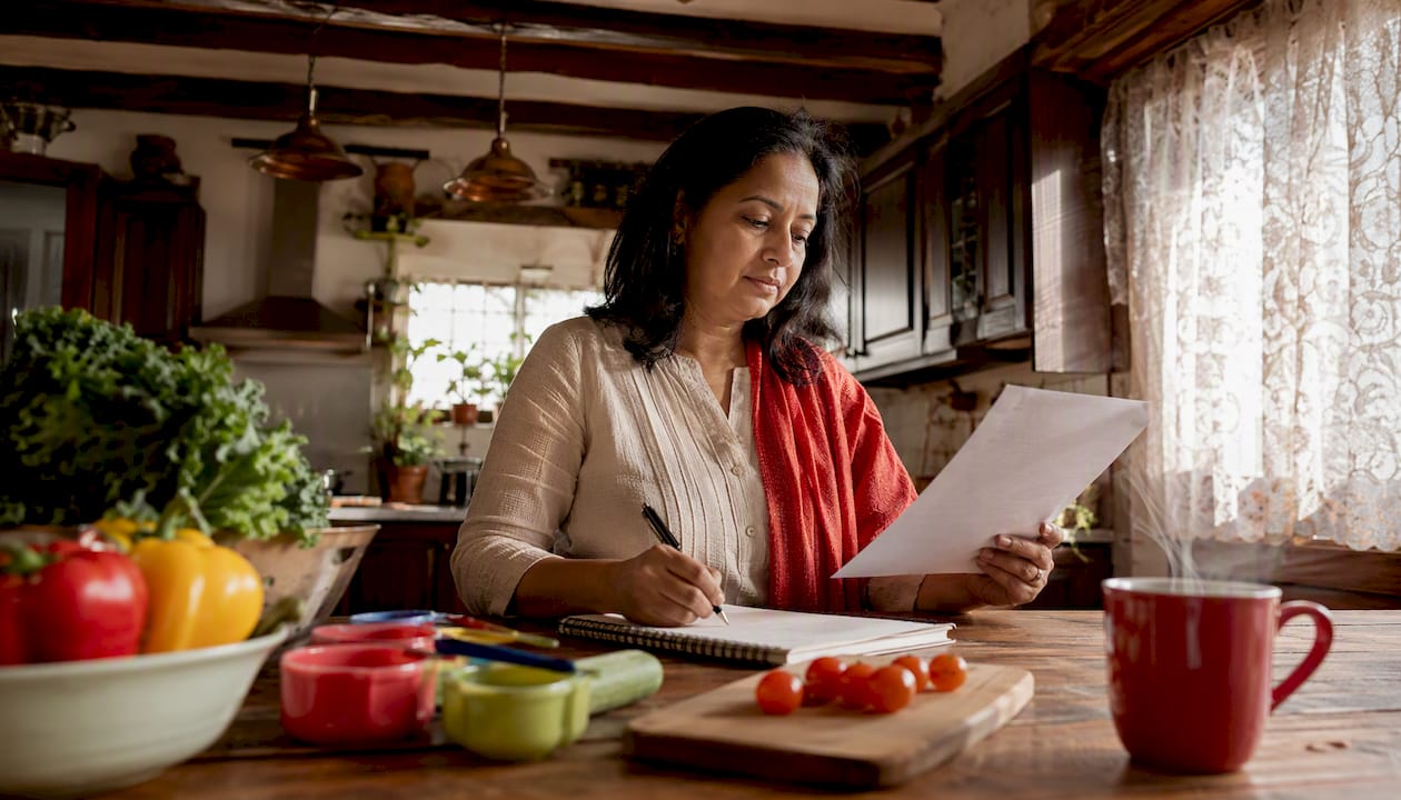Woman planning DASH diet meals in kitchen