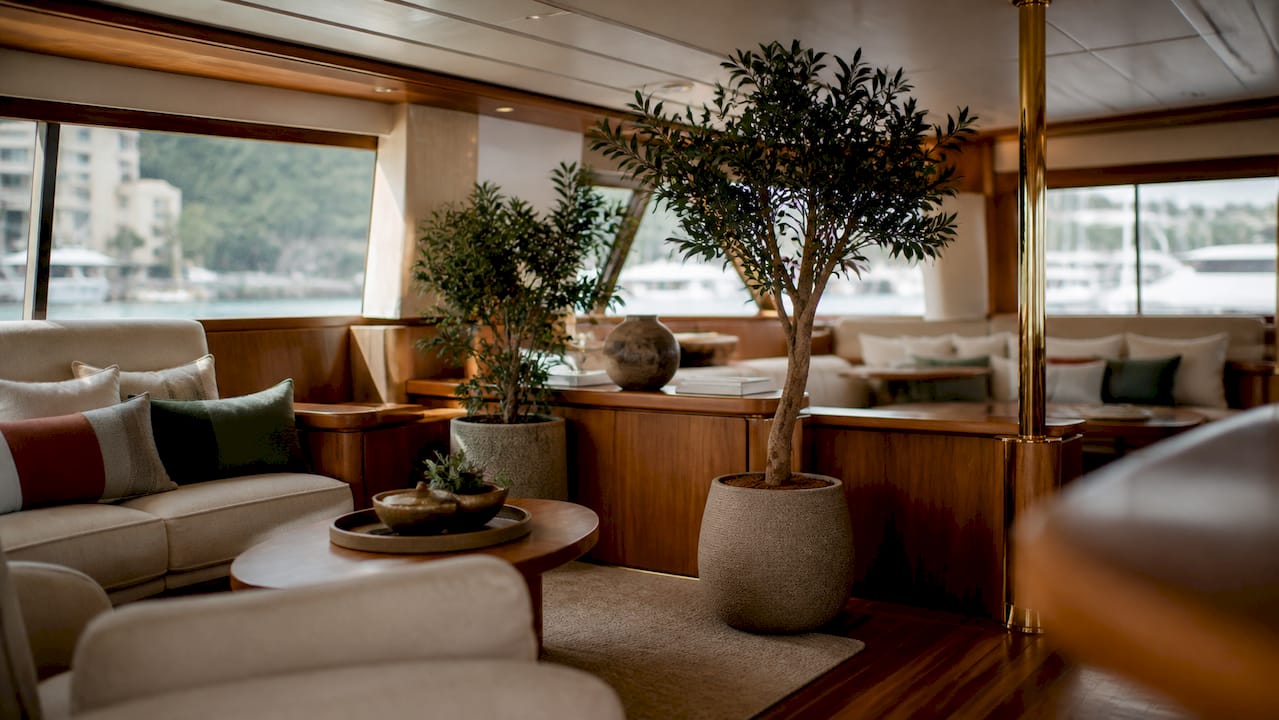 Stilvolle Details im Yachtinterieur: Stoffelemente und elegante Pflanzengefäße aus Messing schaffen ein exklusives Ambiente.