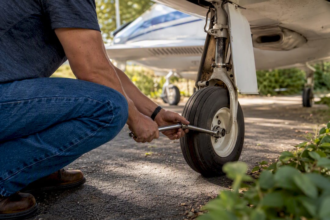 Hands changing aircraft nose tire