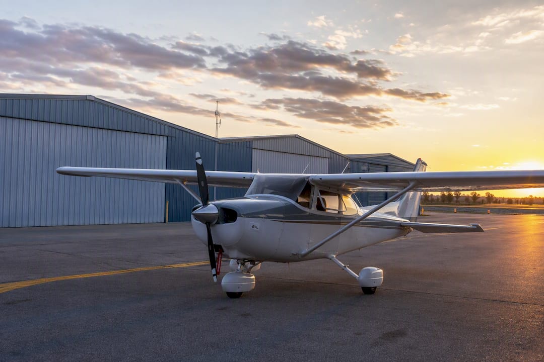 Small GA aircraft parked on ramp at sunset