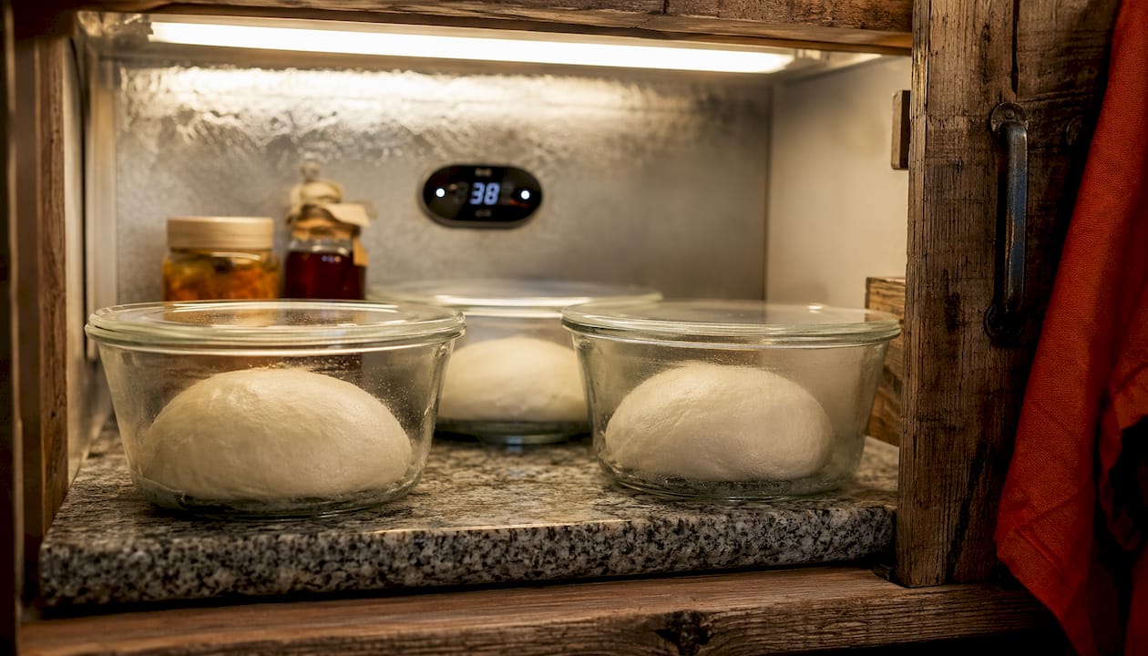 Dough balls fermenting in fridge containers