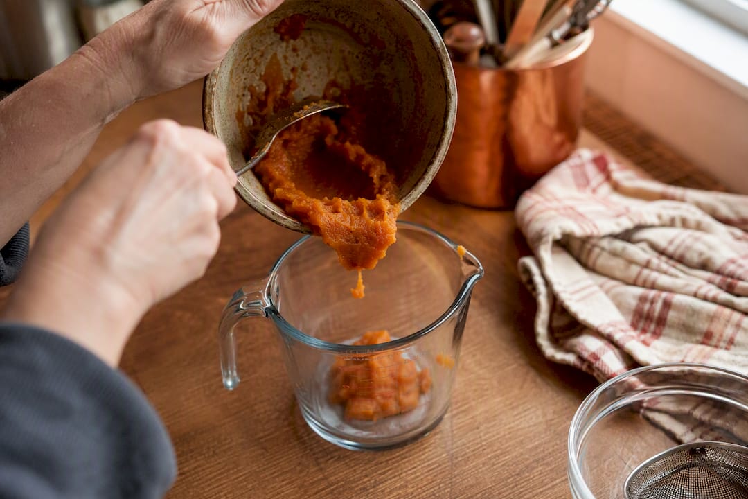 Hands measuring applesauce as egg substitute