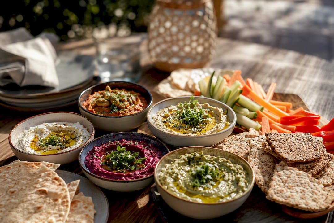 Small bowls of dips with garnishes on tray