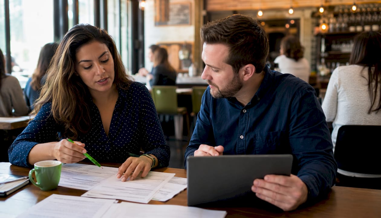 Two colleagues reviewing payroll setup paperwork together