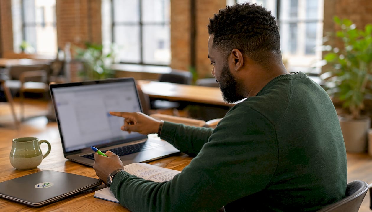 Hands tagging contractor payments on laptop