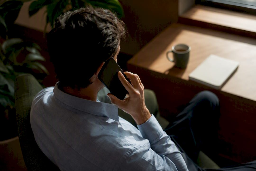 Personne en pleine conversation téléphonique, allant droit au but pour négocier efficacement.