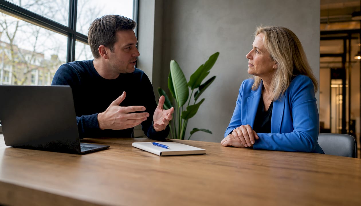 Twee professionals overleggen samen over het kiezen van de juiste OKR-coach.
